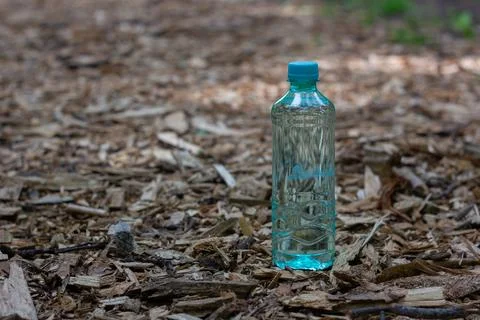 A single-use plastic water bottle stands on a path  Stock Photos