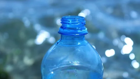 A single water bottle sits on a flat surface, surrounded by empty space Stock Footage 342428426