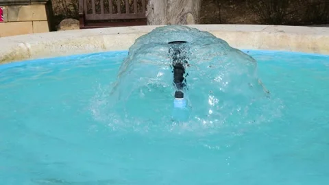 Single water jet rises from a round stone garden fountain close up valletta Stock Footage 341803682