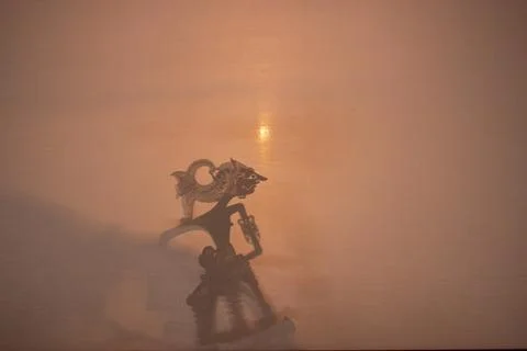 Single Wayang Kulit Shadow Puppet on Warm Backlit Screen Stock Photos