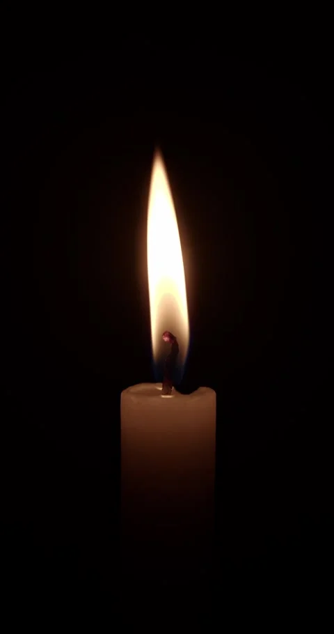 Single White Candle Burning Against Dark Background in Vertical Stock-Footage 331851425