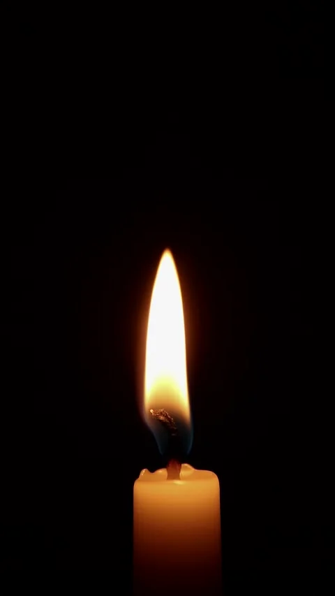 A single white candle is burning. Isolated burning candle on a dark background. Stock Footage 192902670