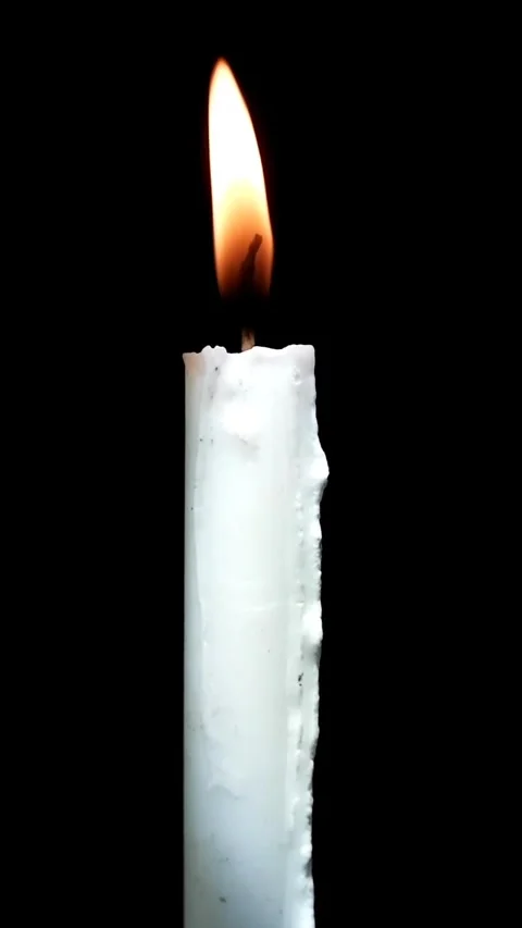 A single white candle flame glowing softly in the dark Stock Footage 320290790