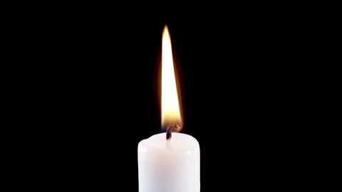 Single white candle flame lights, isolated on a black background. slow motion Stock Footage 220214792