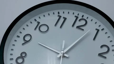 Single white clock hanging on wall time lapse cinematic concept of film Stock Footage 336444952