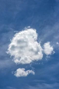 Single white cloud in blue sky vertical view 库存照片