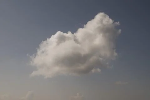 Single white cloud in a bright blue sky Stock Photos