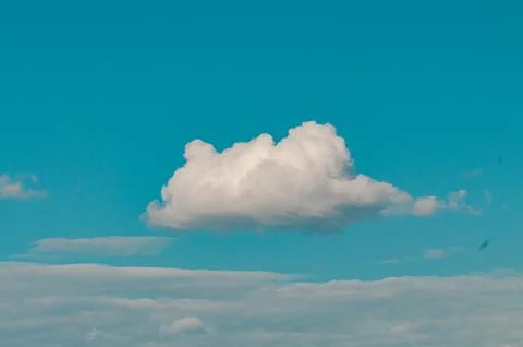 Single white cloud in a bright blue sky Stock Photos