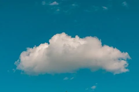 Single white cloud in a bright blue sky Stock Photos