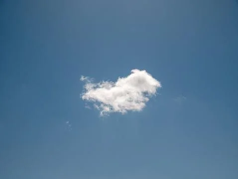 Single white cloud in a clear blue sky Фото