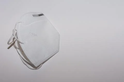 Single white FFP2 or KN95 mask on white background left Stock Photos