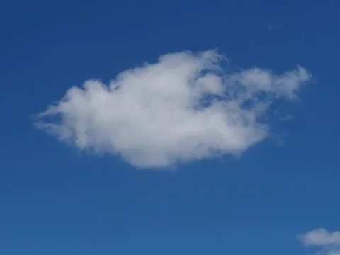 Single white fluffy cloud in blue sky Stock Photos