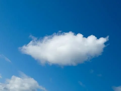 Single white fluffy cumulus cloud in the blue summer sky Photos