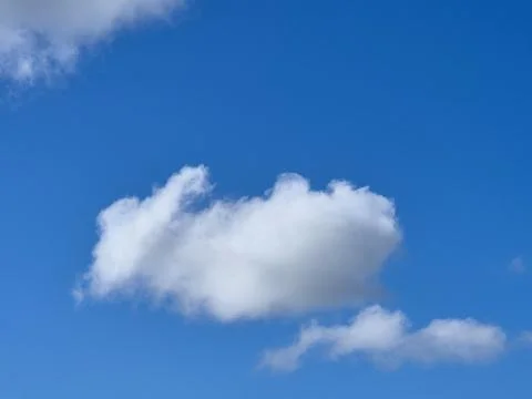 Single white fluffy cumulus cloud in the blue summer sky Photos