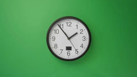 Single white office clock hanging on green background, timelapse Stock Footage 136757020