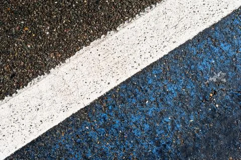 Single white road marking in diagonal composition with black bitumen and ston Stock Photos