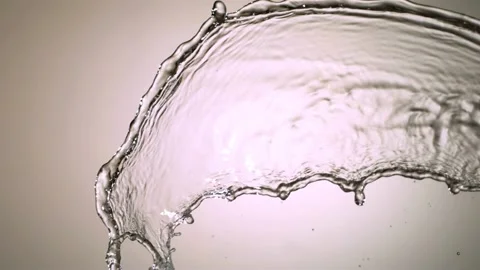 A single whole lemon drops into water creating a large splash with bubbles Video stock 326627064