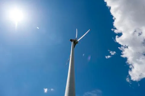 Single wind power engine with cloud and sun Stock Photos