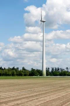 Single wind power engine in farm field Stock Photos