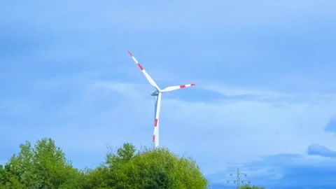 Single Wind Turbine Rotating Above Rural Farmland Stock Footage 345654393