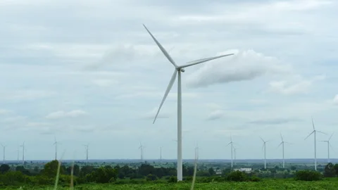 Single wind turbine standing tall on green grass hill against blue sky and cloud Stock Footage 342905991
