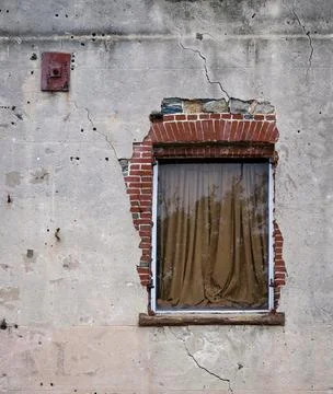Single window in ancient wall with brick revealed erosion. Stock Photos