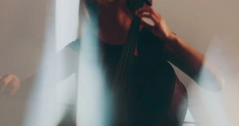 Single woman playing the cello, close-up and medium Stock Footage 240129137