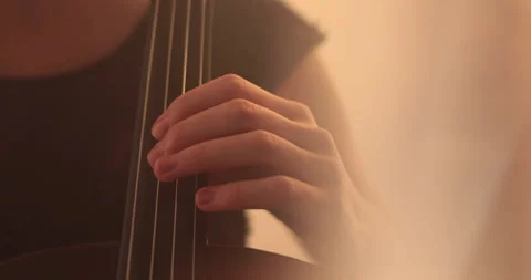 Single woman playing the cello, close-up and medium Stock Footage 240132425