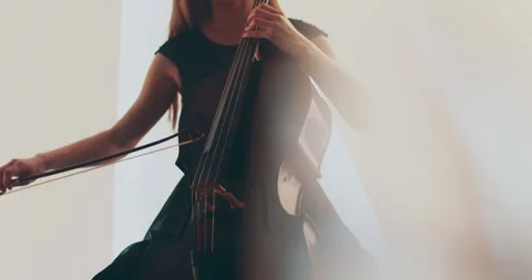 Single woman playing the cello, close-up and medium Stock Footage 240133091
