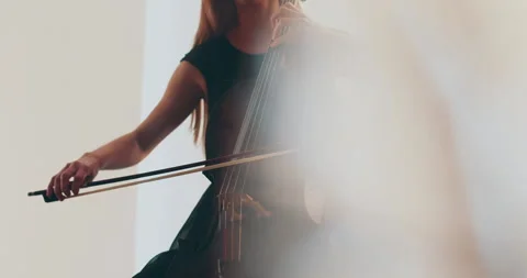Single woman playing the cello, close-up and medium Stock Footage 240133100