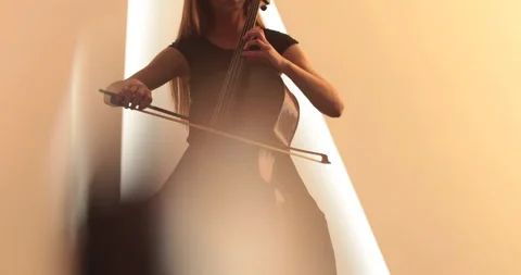 Single woman playing the cello, close-up and medium Stock Footage 240134010