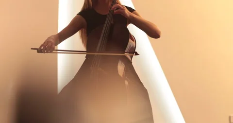 Single woman playing the cello, close-up and medium Stock Footage 240134064