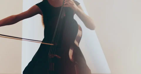 Single woman playing the cello, close-up and medium Stock Footage 240134425