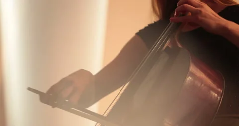 Single woman playing the cello, close-up and medium Stock Footage 240136483