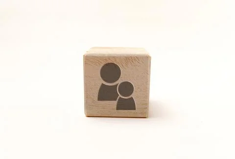 Single wooden block cube featuring a gray icon of two people or family on n.. Stock Photos