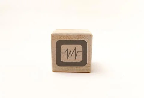 Single wooden block cube featuring a gray heart rate pulse icon on natural .. Stock Photos