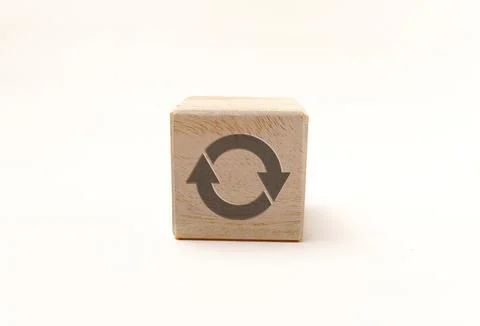 Single wooden block cube featuring a gray circular refresh or recycle icon .. Stock Photos
