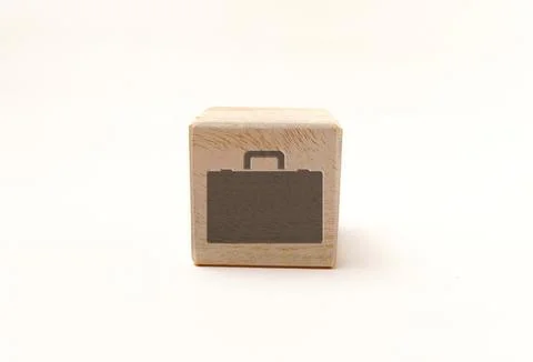 Single wooden block cube featuring a gray briefcase work icon on natural gr.. Stock Photos
