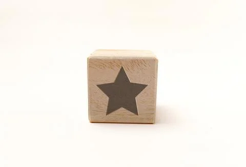 Single wooden block cube featuring a gray five-point star icon on natural g.. Stock Photos