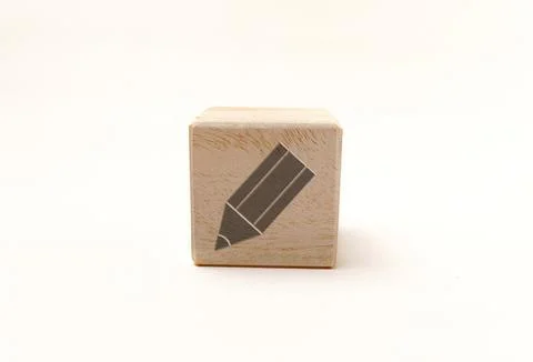 Single wooden block cube featuring a gray pencil edit icon on natural grain.. Stock Photos