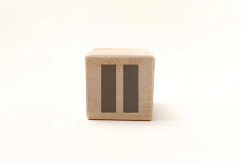 Single wooden block cube featuring a gray pause media control icon on natur.. Stock Photos
