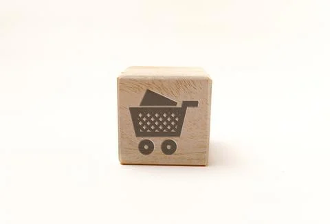 Single wooden block cube featuring a gray shopping cart retail icon on natu.. Stock Photos