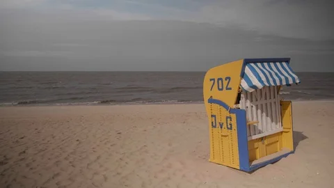 A single yellow beach chair in front of the north sea Stock Footage 100106186