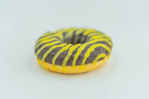 A single yellow-iced doughnut with a zigzag pattern and chocolate sprinkles,  Stock Photos