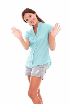 Single young lady gesturing a greeting while looking at you standing and smil Stock Photos