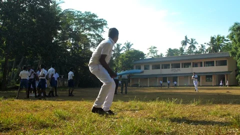 Sinhalese boy in white school uniform bats ball 库存影片 115035508