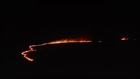 Sinister Winds Carry Blaze Through Dark Meadow. Aerial Drone Shot. Stock Footage 257769436
