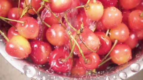 In the sink cherry in a colander under the water slow motion Stock Footage 90488628