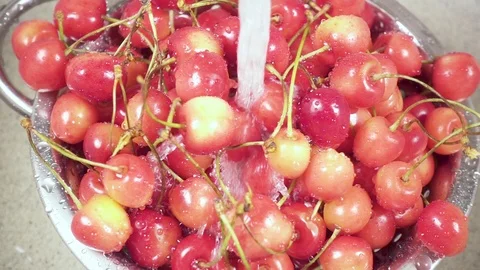 In the sink cherry in a colander under the water slow motion Stock Footage 90488688