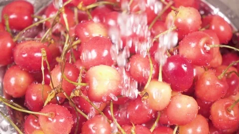 In the sink cherry in a colander under the water slow motion Stock Footage 90488771